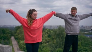 Parkta birbirine aşık genç bir çift spor yapıyor. Sağlıklı yaşam tarzı senkronize hareketleri ısıtıyor.