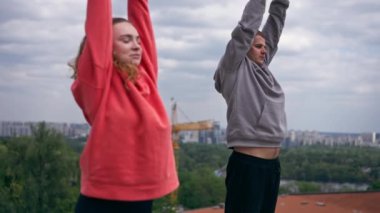 Parkta birbirine aşık genç bir çift spor yapıyor. Sağlıklı yaşam tarzı senkronize hareketleri ısıtıyor.
