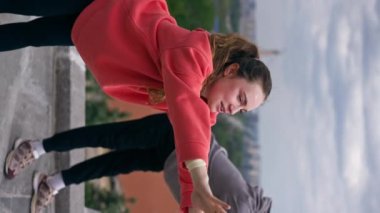 Parktaki genç çiftin spor yaparken çektikleri dikey video sağlıklı yaşam tarzlarını senkronize ediyor.