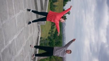 Parktaki genç çiftin spor yaparken çektikleri dikey video sağlıklı yaşam tarzlarını senkronize ediyor.