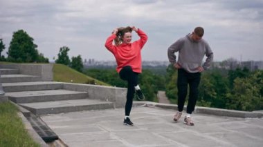 Parkta birbirine aşık genç bir çift spor yapıyor. Sağlıklı yaşam tarzı senkronize hareketleri ısıtıyor.