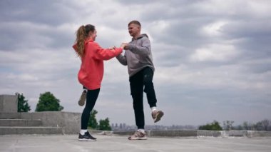 Parkta birbirine aşık genç bir çift spor yapıyor. Sağlıklı yaşam tarzı senkronize hareketleri ısıtıyor.