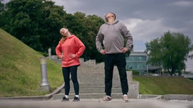 Parkta birbirine aşık genç bir çift spor yapıyor. Sağlıklı yaşam tarzı senkronize hareketleri ısıtıyor.