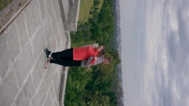 Parktaki genç çiftin spor yaparken çektikleri dikey video sağlıklı yaşam tarzlarını senkronize ediyor.