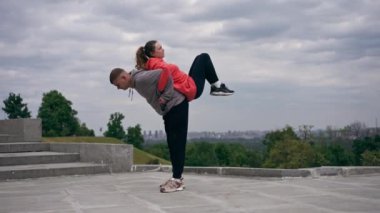 Parkta birbirine aşık genç bir çift spor yapıyor. Sağlıklı yaşam tarzı senkronize hareketleri ısıtıyor.