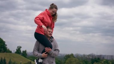 Parkta birbirine aşık genç bir çift spor yapıyor. Sağlıklı bir yaşam tarzını ısıtıyor. Senkronize hareketler.