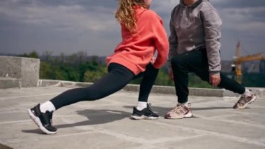 Parkta birbirine aşık genç bir çift spor yapıyor. Sağlıklı yaşam tarzı senkronize hareketleri ısıtıyor.