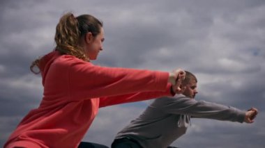 Parkta birbirine aşık genç bir çift spor yapıyor. Sağlıklı yaşam tarzı senkronize hareketleri ısıtıyor.