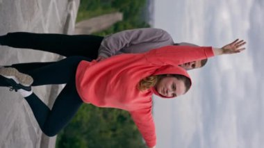 Parktaki genç çiftin spor yaparken çektikleri dikey video sağlıklı yaşam tarzlarını senkronize ediyor.