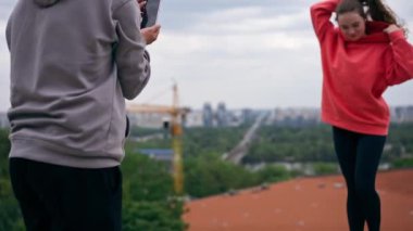 Parkta genç bir çift spor sonrası fotoğraf çekiminden sonra fotoğraf çekiyor.