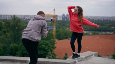 Parkta genç bir çift spor sonrası fotoğraf çekiminden sonra fotoğraf çekiyor.