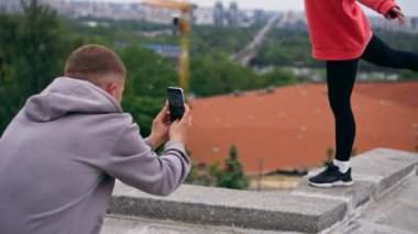 Parkta genç bir çift spor sonrası fotoğraf çekiminden sonra fotoğraf çekiyor.