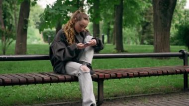 Parkta siyah ceketli, saçları yerden kesilmiş, cep telefonuyla mesajlaşan yalnız bir kız vardı.