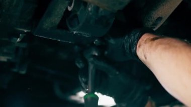 Bir benzin istasyonundaki oto tamirciyi kapat asansörde kaldırılan bir arabayı kontrol et, mekanik bir araçla arızaları düzelt motor alt gövdenin parçasını