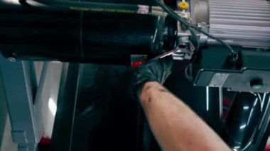 Araba servis merkezindeki kırmızı direğin dikey görüntüsü. Arabayı tamir için kaldırma mekanizması var.