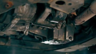 Bir benzin istasyonundaki oto tamirciyi kapat asansörde kaldırılan bir arabayı kontrol et, mekanik bir araçla arızaları düzelt motor alt gövdenin parçasını