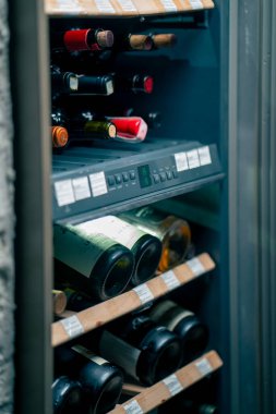 Restorana yakın profesyonel bir buzdolabı var. Doğru sıcaklıkta şarap şişeleri depolamak için ahşap raflar var.