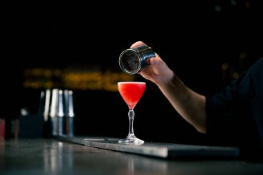 Güzel kristal bardakla kırmızı alkolik içeceği yakın plan. Adamın biri demir biberlikten çikolata tozuyla süslemiş.