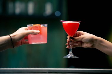 Barda ya da disko kulübünde içki ve kokteyl konseptinde tezahürat yapan iki kişiye yakın durun.