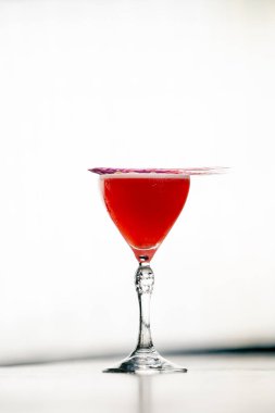 Yakın plan kırmızı bir kokteyl, beyaz bir arka plan, bir bar restoranında portakal suyu, taze hazırlanmış alkol için de buzdolabı.
