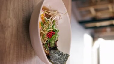 Bir fast food işletmesine yakın bir yerde siyah üniformalı büyük bir şef Japon udon çorbasını hazırlıyor.