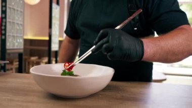 Bir fast food restoranında dikey video portresi. Siyah üniformalı büyük bir şef Japon udon çorbasını hazırlıyor.