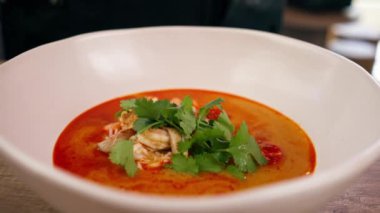 Bir fast food işletmesinde siyah üniformalı büyük bir şef Japon udon çorbasını hazırlar ve çorba döker.