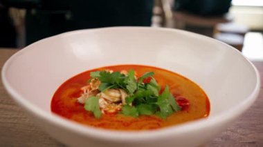 Lokantada, hafif bir masada, Japon udon çorbası, karides ve pirinç çorbası ile birlikte beyaz bir tabak.