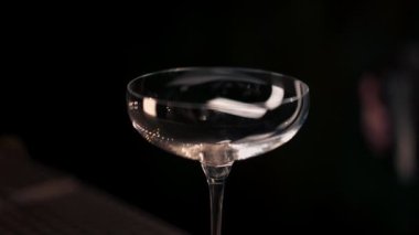 Erkek barmen barmene yaklaşın. Çelik bardaktan bardaktaki eleğe kadar alkollü bir içecek doldurun.