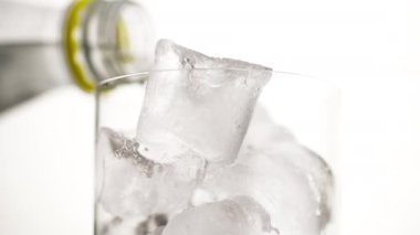 Arka planda bir şarap kadehinin makro çerçevesi kaba bir şekilde ezilmiş buzla bardakta susuzluk giderici alkollü içecek dökülüyor.