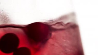 gözlüklerden makro çerçeve soğuk kırmızı kokteyl buz küpleri yoğunlaştırma ve cam meyveli kırmızı toplar üzerine damla