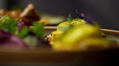 Profesyonel bir mutfakta, temiz metal bir masada, ahşap bir tabakta, domatesli ve mozzarella tostlu güzel bir salata.