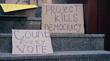 Protestocuların işaretleri mermer merdivenlerde, cumhurbaşkanlığı seçim kampanyasında, halkın haklarını koruyan protestocuların yozlaşmış kampanyalarında yatıyor.