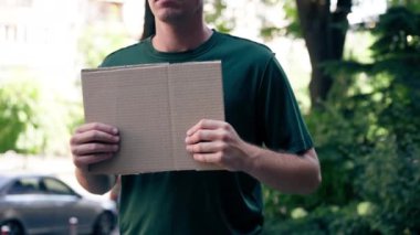 Elinde boş bir tabelayla protestocuyu kapatıyordu. Başkanlık seçim kampanyası. Rüşvet, protestocuların kamu haklarını savunması.