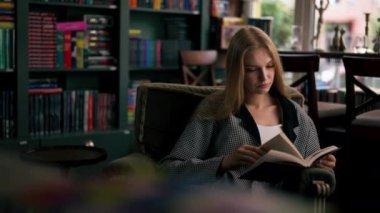 Güzel bir kitapçıda, uzun saçlı genç bir kız kitap akşamları boş zamanlarını kitap okuyarak geçiriyor.