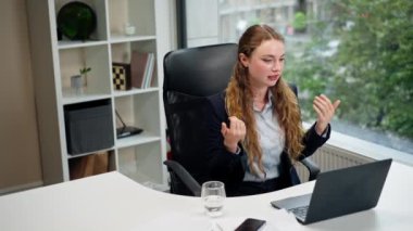 Modern bir ofiste geniş bir penceresi olan mavi gömlekli güzel bir işçi dizüstü bilgisayarlı bir konuşma yaparak şirketler arasında arkadaşlık kuran bir video görüşmesi yaptı.