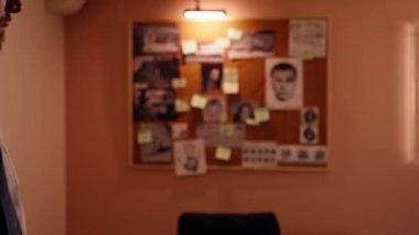 Dedektiflik bürosunda, gömlekli ve kravatlı orta yaşlı bir dedektif büyüteçle inceler kanıt inceler suçlu fotofit güzergahı suçlularını bulmak için ipuçlarını inceler.