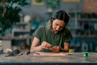 in a large green workshop on a woman with green hair creates decorative flowers working with metal tape decor on the mirror handicrafts clipart