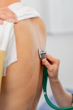 Modern bir klinikte, küçük bir terapistin ofisinde, steteskoplu genç bir kız doktor, genç bir hastayla randevu ayarlar, bir sorunu teşhis eder, akciğerleri dinler.