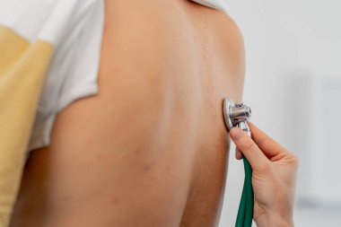 Modern bir klinikte, küçük bir terapistin ofisinde, steteskoplu genç bir kız doktor, genç bir hastayla randevu ayarlar, bir sorunu teşhis eder, akciğerleri dinler.