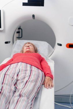 Beyaz bir ofisteki modern bir klinikte yaşlı bir kadının, yakınlardaki genç bir doktorun beyin MR 'ı için bir ilaç.