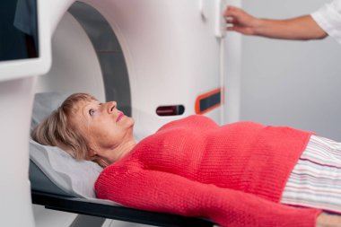 Beyaz bir ofisteki modern bir klinikte yaşlı bir kadının, yakınlardaki genç bir doktorun beyin MR 'ı için bir ilaç.