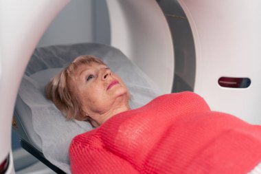 Beyaz bir ofisteki modern bir klinikte yaşlı bir kadının, yakınlardaki genç bir doktorun beyin MR 'ı için bir ilaç.