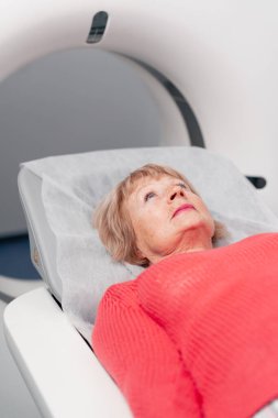 Beyaz bir ofisteki modern bir klinikte yaşlı bir kadının, yakınlardaki genç bir doktorun beyin MR 'ı için bir ilaç.