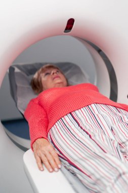 Beyaz bir ofisteki modern bir klinikte yaşlı bir kadının, yakınlardaki genç bir doktorun beyin MR 'ı için bir ilaç.