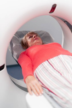 Beyaz bir ofisteki modern bir klinikte yaşlı bir kadının, yakınlardaki genç bir doktorun beyin MR 'ı için bir ilaç.