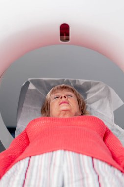 Beyaz bir ofisteki modern bir klinikte yaşlı bir kadının, yakınlardaki genç bir doktorun beyin MR 'ı için bir ilaç.