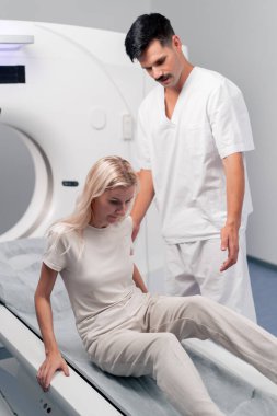 Modern bir klinikte, beyaz bir ofiste, MRI için bir ilaç, genç bir kızın beyninin incelenmesi, yıllık muayene