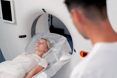 Modern bir klinikte, beyaz bir ofiste, MRI için bir ilaç, genç bir kızın beyninin incelenmesi, yıllık muayene