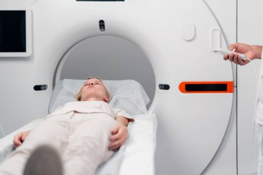 Modern bir klinikte, beyaz bir ofiste, MRI için bir ilaç, genç bir kızın beyninin incelenmesi, yıllık muayene